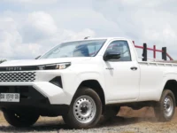 Tampilan depan atau tampak samping dari mobil New Toyota Hilux Palangka Raya varian double cabin dengan latar belakang pemandangan kota.