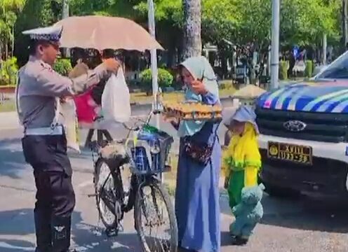 Personel Satlantas Polresta Palangka Raya membagikan bantuan kepada masyarakat melalui Program 1 Hari 1 Kebaikan.